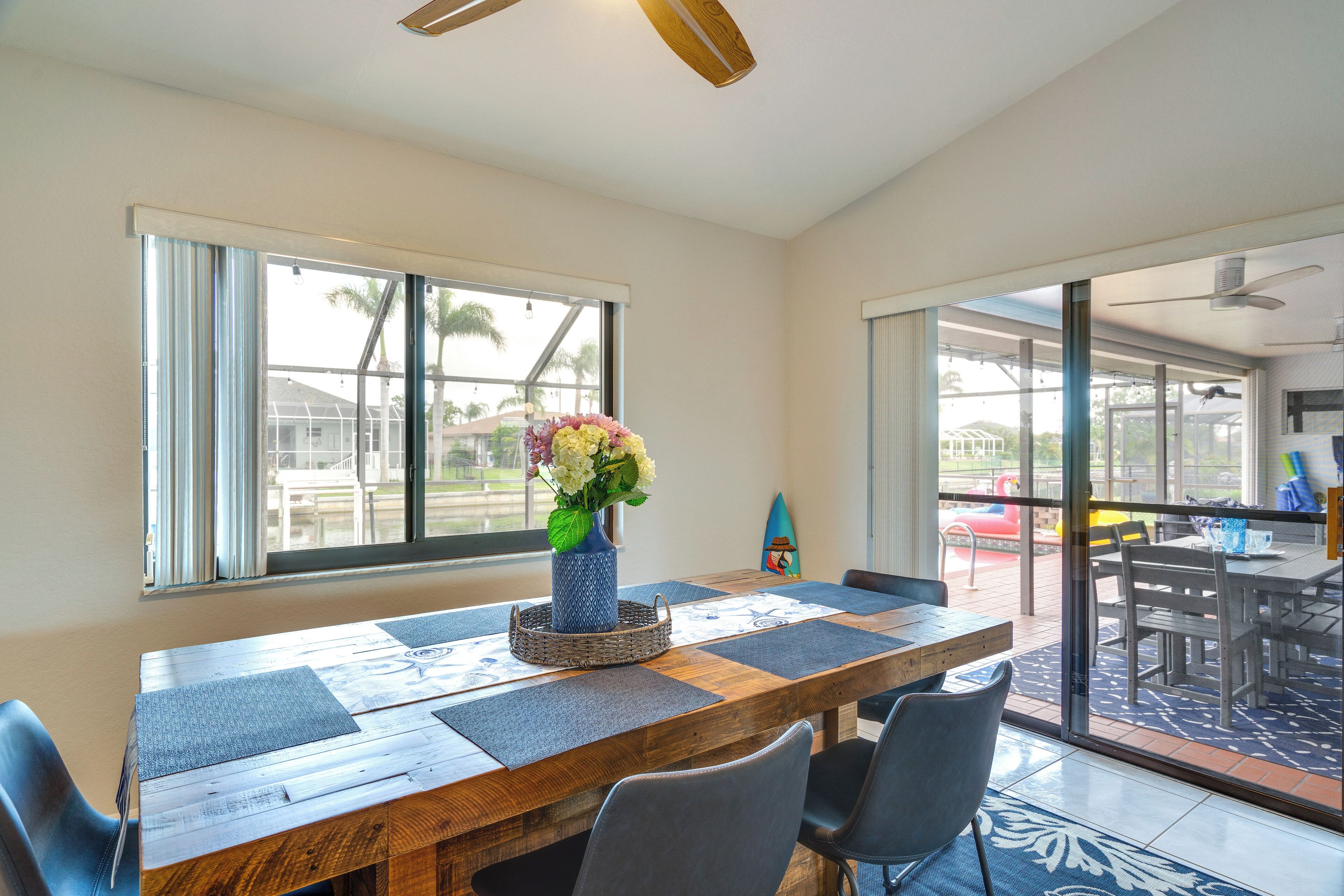 A dining area with a wooden table, blue chairs, and a vase of flowers.