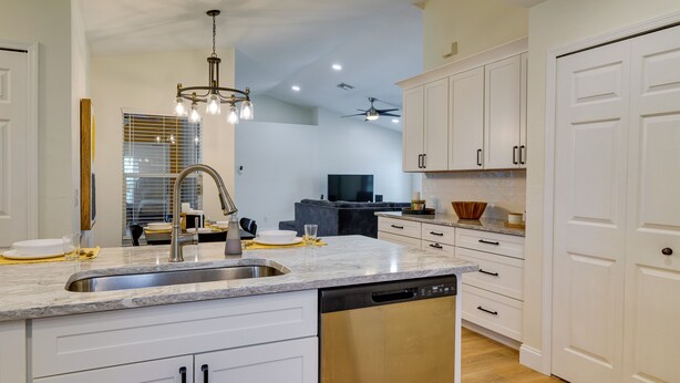 A modern kitchen with white cabinetry, a stainless steel sink, and a dishwasher. - Heated Pool: Pet-friendly Home in Cape Coral (Cape Coral)