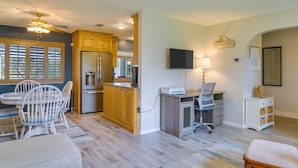 A modern kitchen with wooden cabinets, a built-in refrigerator, and a dining area with a table and chairs. - Cape Coral Home w/ Private Heated Pool & Lanai! (Cape Coral)