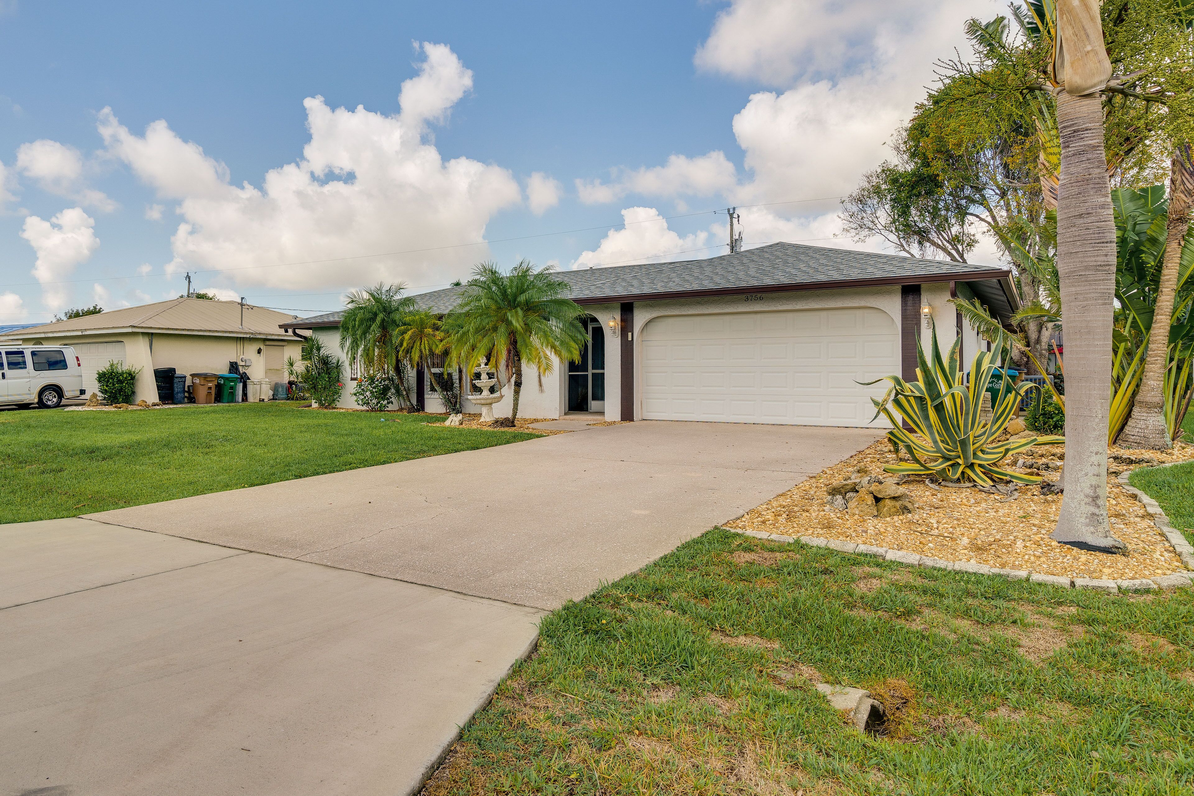 A residential house with a garage, a driveway, and a well-maintained lawn.