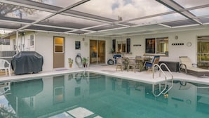 A swimming pool with a covered patio area, outdoor seating, and a view of the sky. - Cape Coral Home w/ Private Heated Pool & Lanai! (Cape Coral)