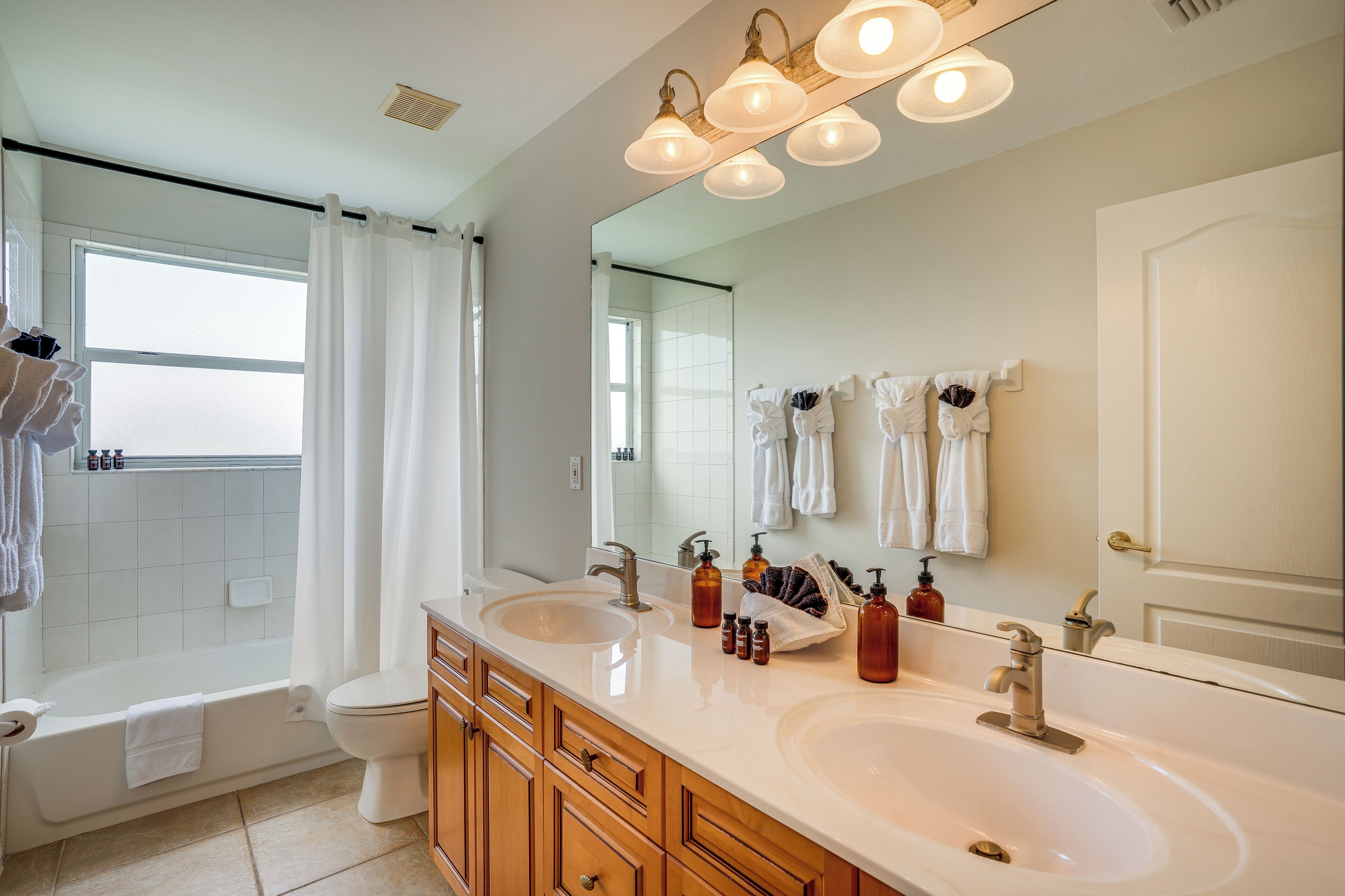 A modern bathroom with a double sink, a bathtub, and a shower.