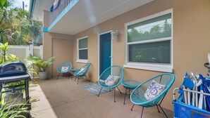 A patio with outdoor seating, a barbecue grill, and a blue door. - Indian Rocks Beach Retreat: Walk to Beaches! (Indian Rocks Beach)