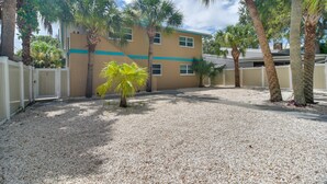 A building with a beige exterior and a white fence. - Indian Rocks Beach Retreat: Walk to Beaches! (Indian Rocks Beach)