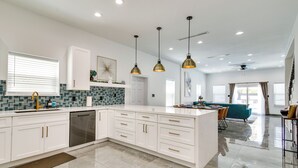 A modern kitchen with white cabinets, a built-in dishwasher, and pendant lighting. - South Padre Island Retreat: Private Pool! (South Padre Island)