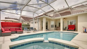 A swimming pool with red canopies, a covered patio, and a ceiling structure. - Lanai & Pool: Spacious Villa Near Disney! (Davenport)