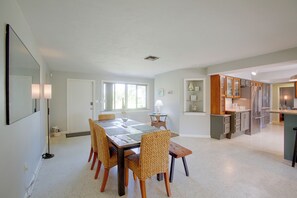 A spacious dining area with a large table and wicker chairs, a kitchen with modern appliances, and a bright, well-lit interior. - Private Dock & Lanai: Waterfront Cape Coral Home! (Cape Coral)