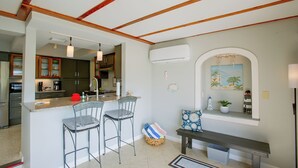 A kitchen with a bar area, a dining table with chairs, and a bench.