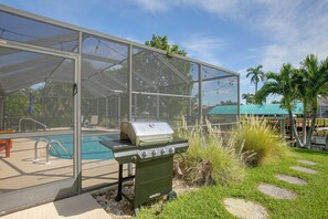 A backyard with a pool, a barbecue grill, and a covered patio area. - Private Dock & Lanai: Waterfront Cape Coral Home! (Cape Coral)