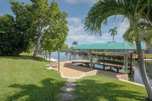 A waterfront park with a gazebo, palm trees, and a dock. - Private Dock & Lanai: Waterfront Cape Coral Home! (Cape Coral)