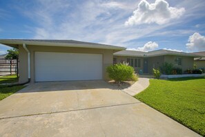 A residential house with a garage, a lawn, and a clear sky. - Private Dock & Lanai: Waterfront Cape Coral Home! (Cape Coral)