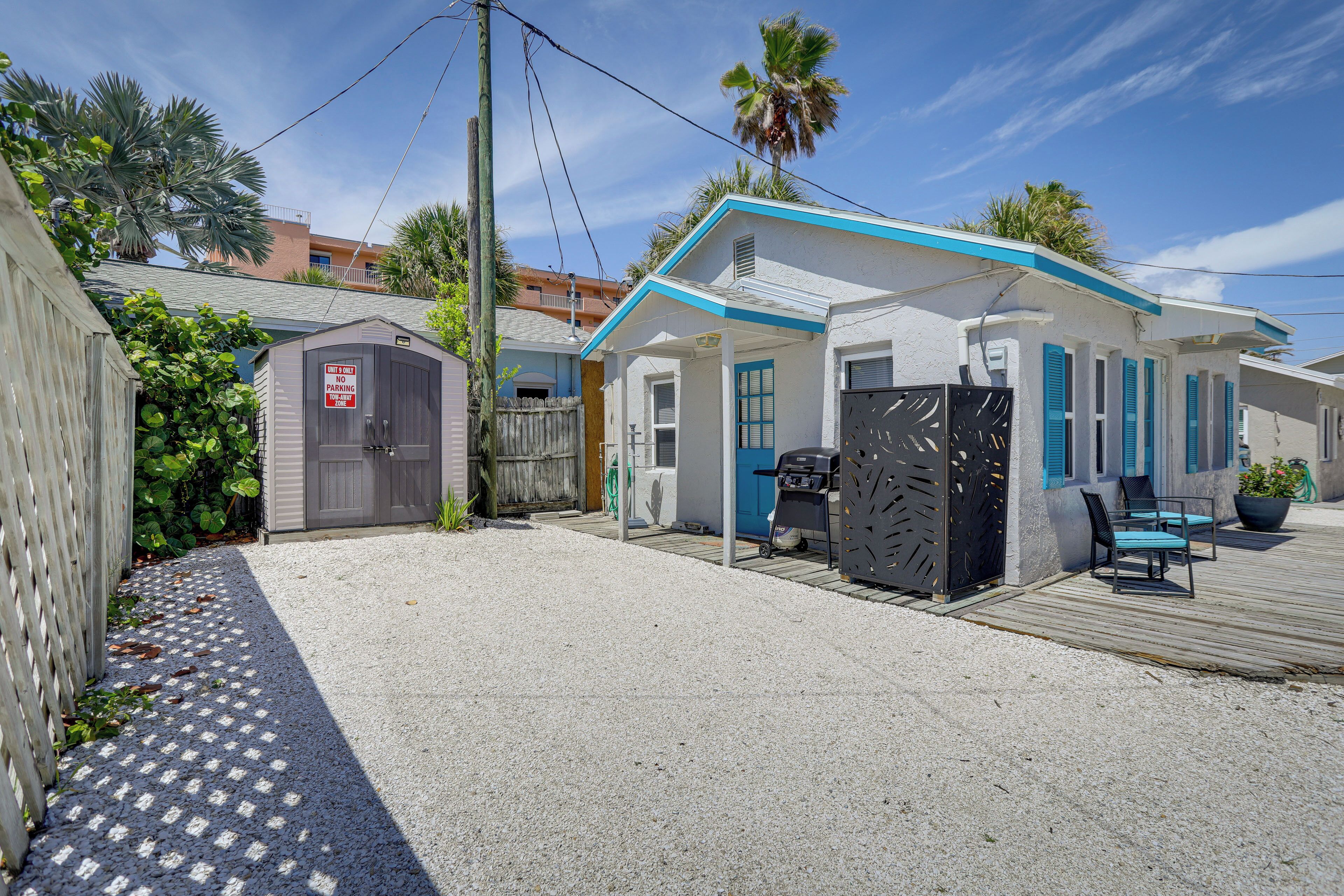A residential property with a covered patio, a barbecue grill, and a small shed.