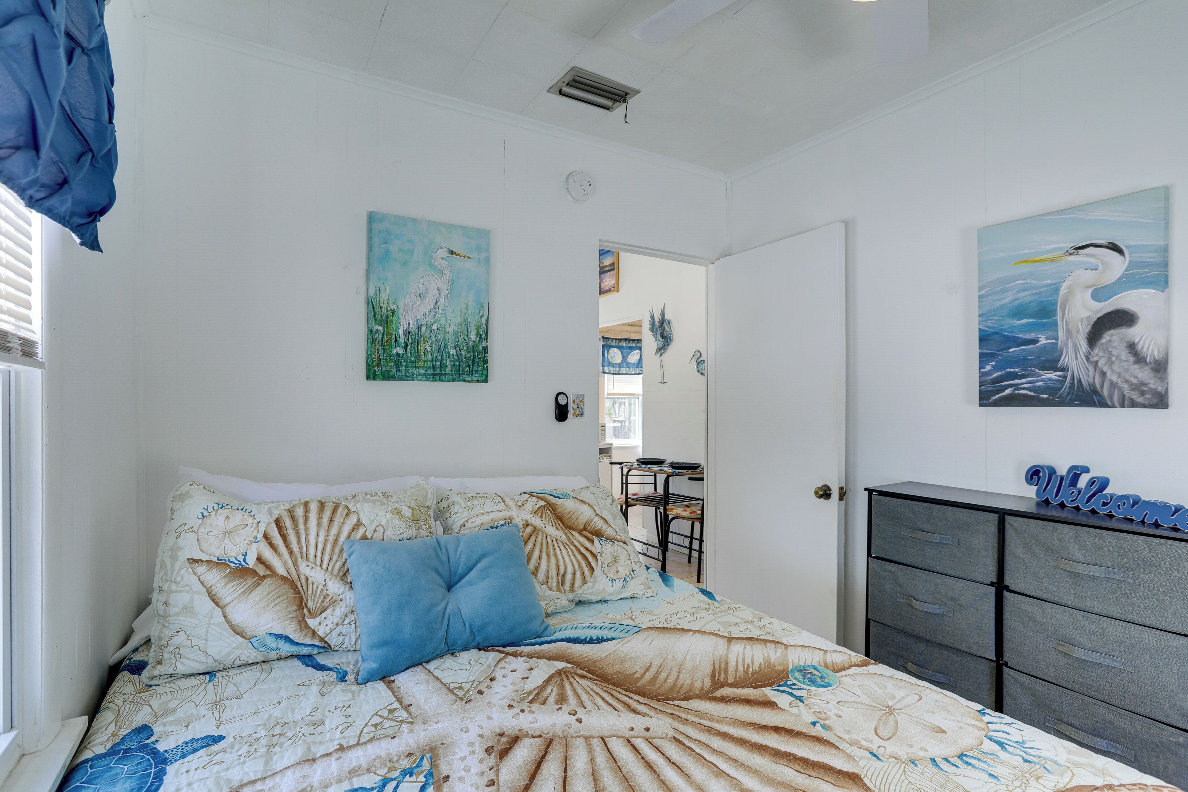 Una camera da letto con un letto, una cassettiera e decorazioni alle pareti.