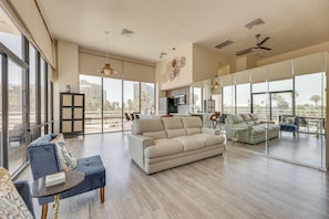 A spacious living area with a sofa, armchairs, and a coffee table. There is a television and a dining area in the background. - South Padre Island Gem: Community Pool & Hot Tub! (South Padre Island)