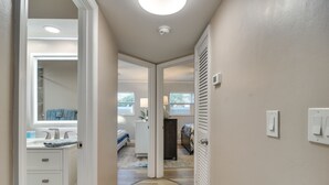 A hallway leading to a bedroom with a bathroom, a ceiling light, and a window. - Indian Rocks Beach Escape: Beach Gear, Near Ocean! (Indian Rocks Beach)