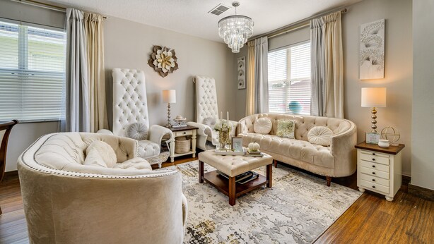 A living room with a tufted sofa, a round armchair, a coffee table, and a chandelier. - Davenport Family Home w/ Private Lanai & Game Room (Davenport)