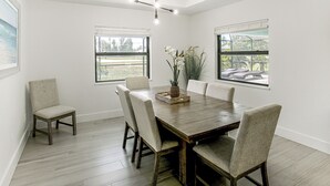 A dining area with a wooden table, six chairs, and a ceiling fan. - Private Pool & Grill: Cape Coral Vacation Rental! (Cape Coral)