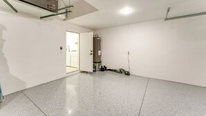 A spacious, well-lit room with a polished floor, a door leading to another area, and a visible electrical panel on the ceiling. - Private Pool & Grill: Cape Coral Vacation Rental! (Cape Coral)