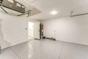 A spacious, well-lit room with a polished floor, a door leading to another area, and a visible electrical panel on the ceiling. - Private Pool & Grill: Cape Coral Vacation Rental! (Cape Coral)