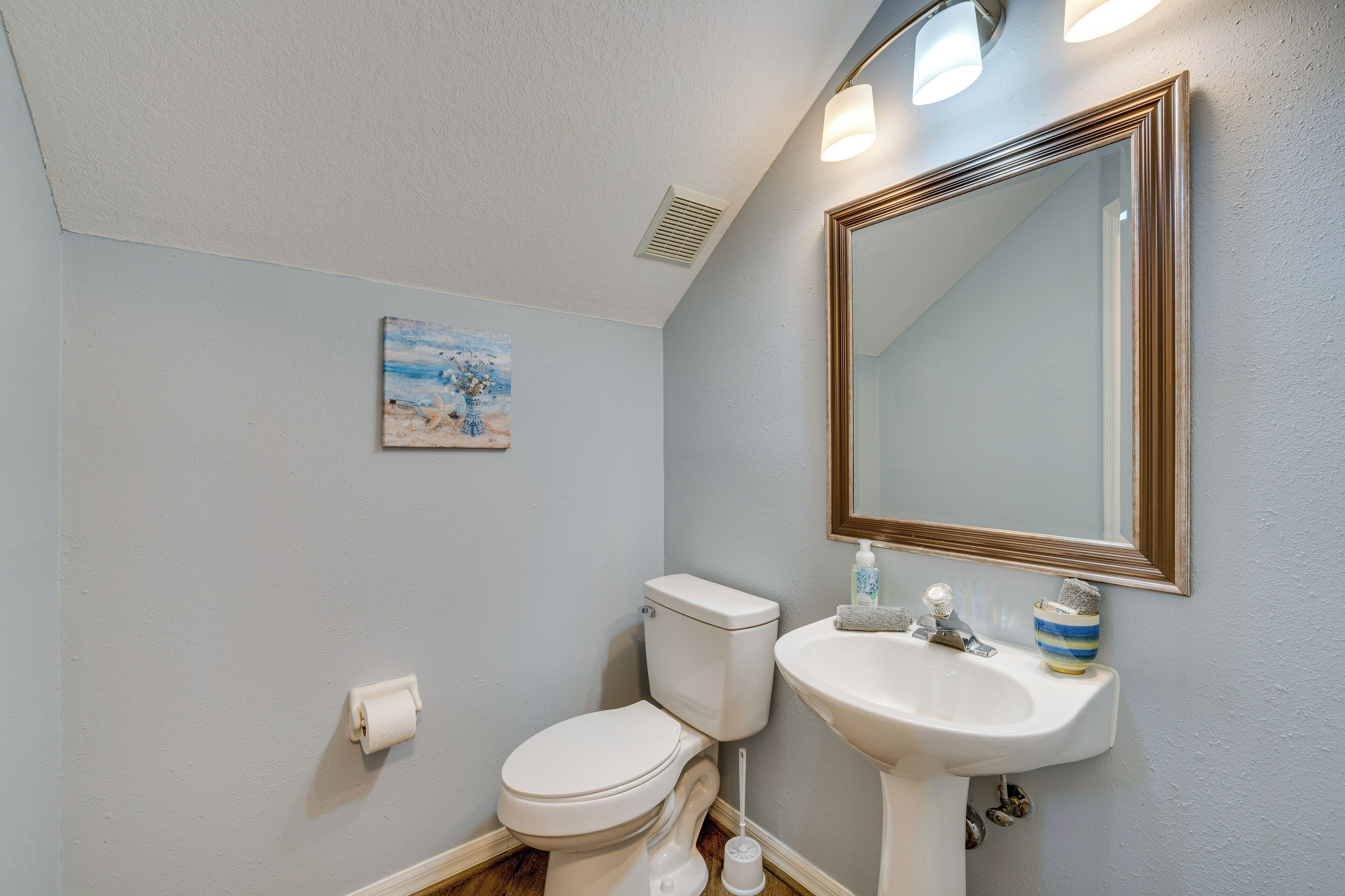 Ein Badezimmer mit Toilette, Waschbecken und Spiegel.