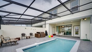 Une piscine extérieure couverte, dotée de chaises longues et d’un espace patio.