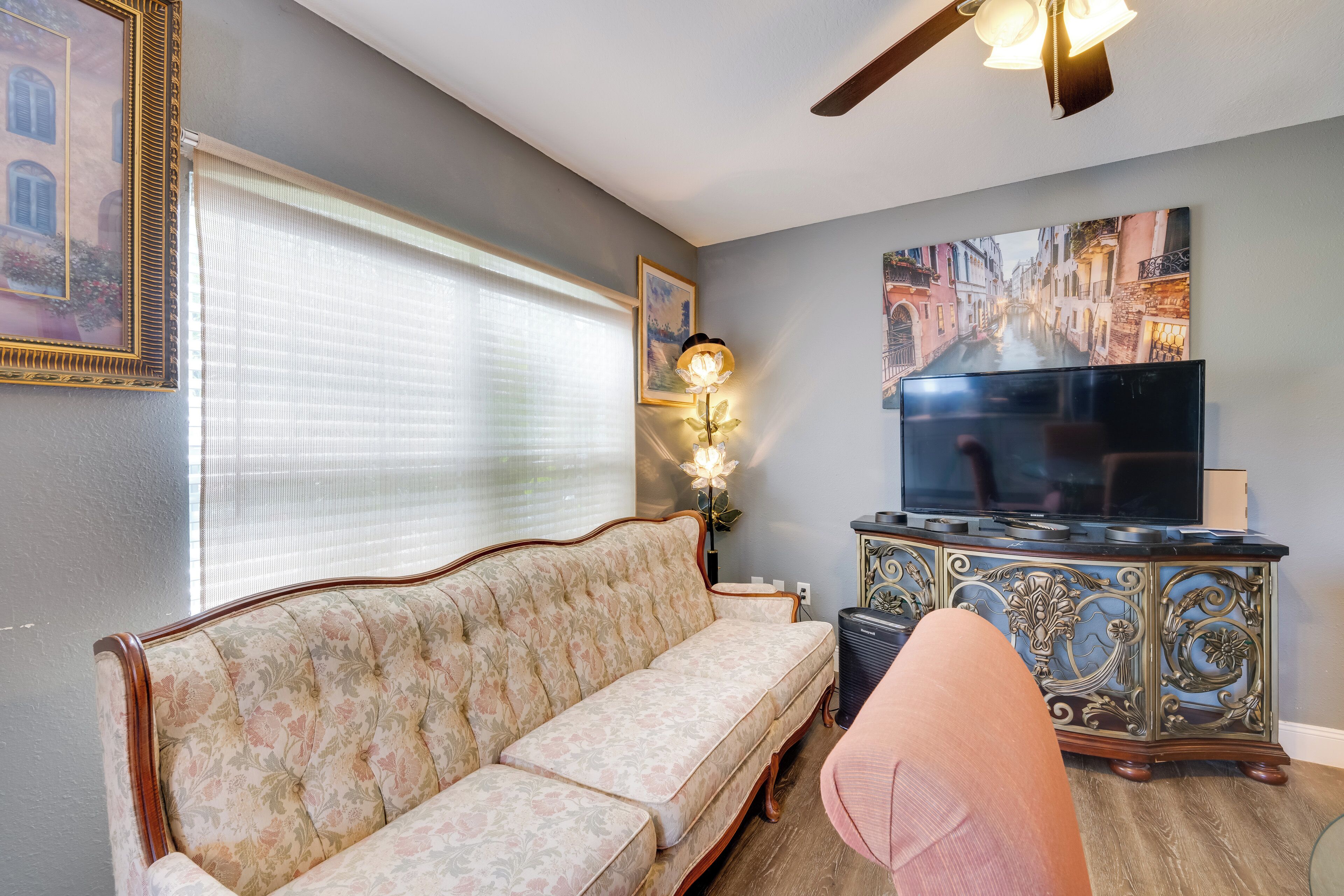 A living room with a sofa, a television, and a decorative cabinet.