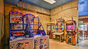 Une salle avec des jeux d’arcade, notamment « Sonic Allstars » et « Big Buck’s ».