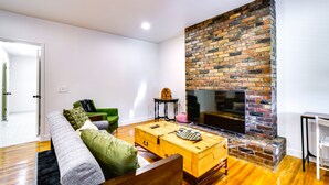 A modern living room with a fireplace, wooden coffee table, and green sofa. - Salt Lake City Escape: Walk to University of Utah! (Salt Lake City)