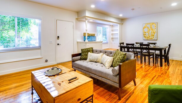 A living room with a sofa, a wooden coffee table, and a dining area with a table and chairs. - Salt Lake City Escape: Walk to University of Utah! (Salt Lake City)
