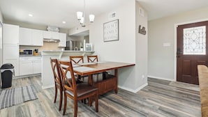A modern kitchen with white cabinets, a dining table with chairs, and a chandelier. - Spacious San Antonio Retreat w/ Private Patio! (San Antonio)