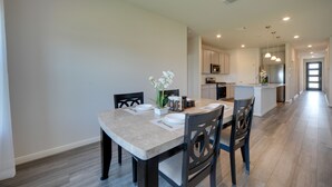 A modern kitchen with white cabinets, a central island, and pendant lighting. - San Antonio Getaway w/ Private Yard & Smart TV (San Antonio)