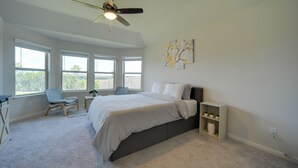 A bedroom with a bed, a chair, a desk, a ceiling fan, and large windows. - San Antonio Getaway w/ Private Yard & Smart TV (San Antonio)