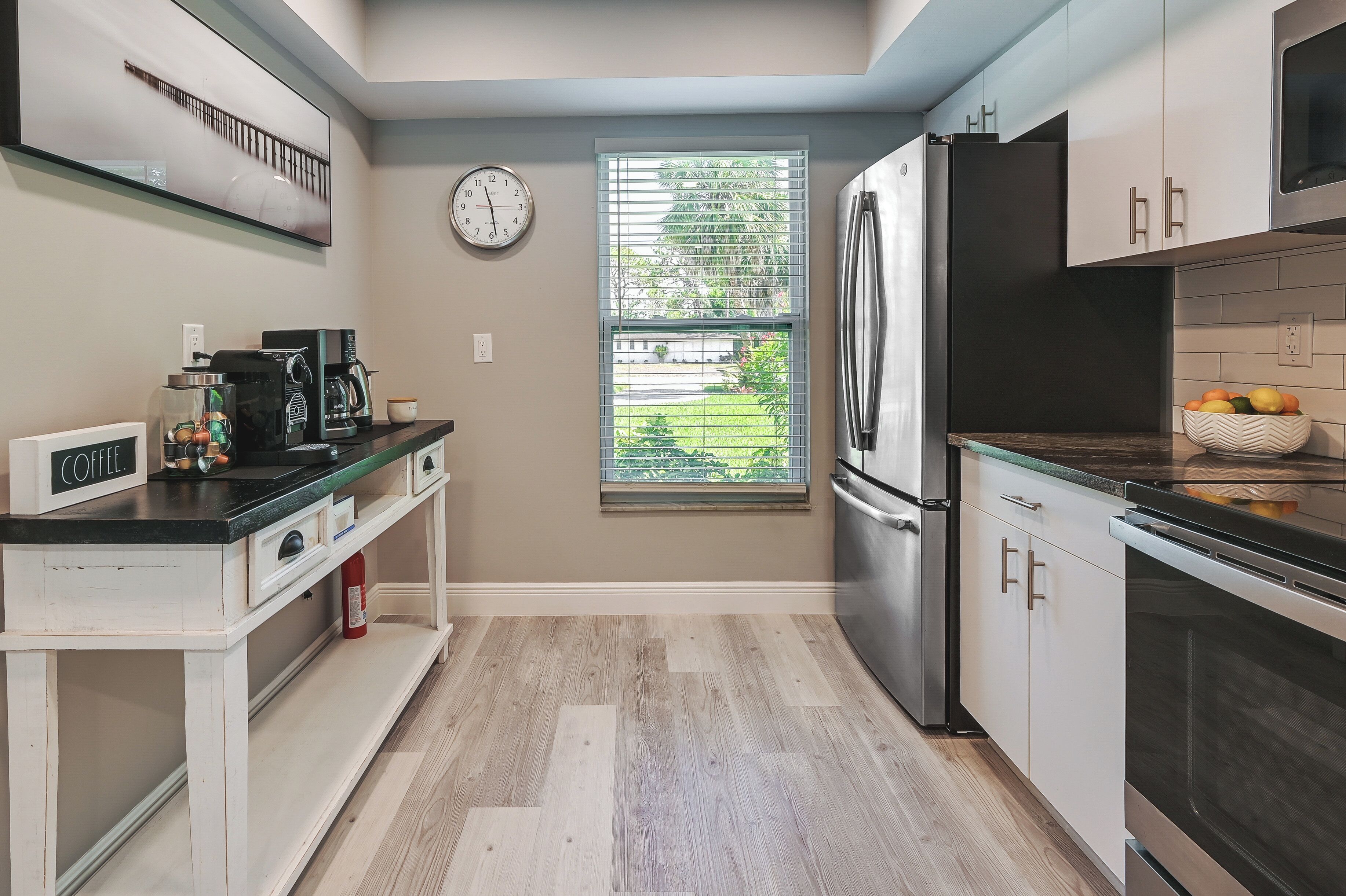 Una cocina compacta con horno integrado, refrigerador y estación para café.