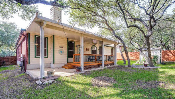 A single-story house with a covered porch, a front door, and a small front yard with a lawn and a tree. - North San Antonio Vacation Rental w/ Yard & Deck! (San Antonio)