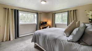A bedroom with a bed, curtains, a desk with a computer, and a window. - Anchorage Home ~ 7 Mi to Chugach State Park! (Anchorage)