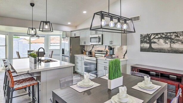 A modern kitchen with a central island, stainless steel appliances, and pendant lighting.