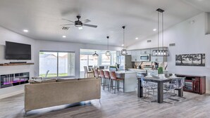 A modern kitchen with a central island, bar stools, and pendant lighting.