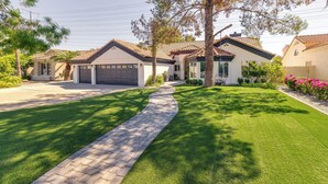 A residential property with a paved driveway, a well-maintained lawn, and a large tree providing shade. - 1 Mi to Water Ranch! Family Retreat w/ Resort Pool (Gilbert)