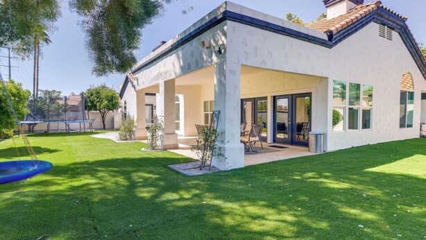 A modern house with a covered patio, a swimming pool, and a well-maintained lawn. - 1 Mi to Water Ranch! Family Retreat w/ Resort Pool (Gilbert)