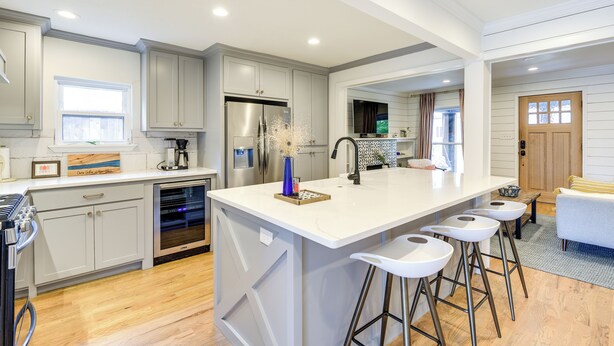 A modern kitchen with a large island, stainless steel appliances, and bar stools. - Pecan Blue Frisco Hub: Dtwn, Dining & Stadiums! (Frisco)