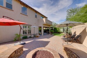 A patio with stone flooring, outdoor furniture, and two umbrellas. - Stunning Phoenix Vacation Rental w/ Private Pool! (Phoenix)