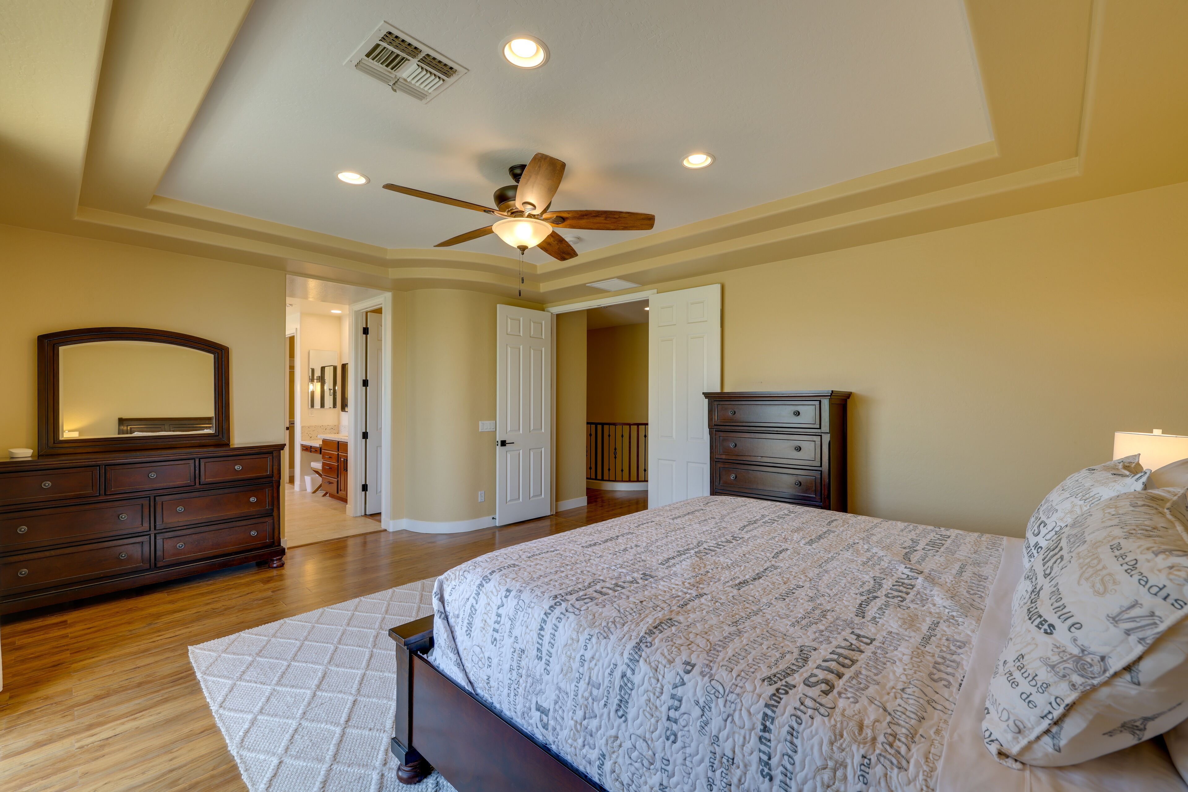 A bedroom with a bed, dresser, and mirror.