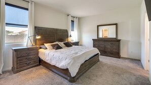 A bedroom with a large bed, wooden nightstands, a dresser, and a mirror. - Sunny Arizona Escape w/ Patio, Grill & Fireplace! (Glendale)
