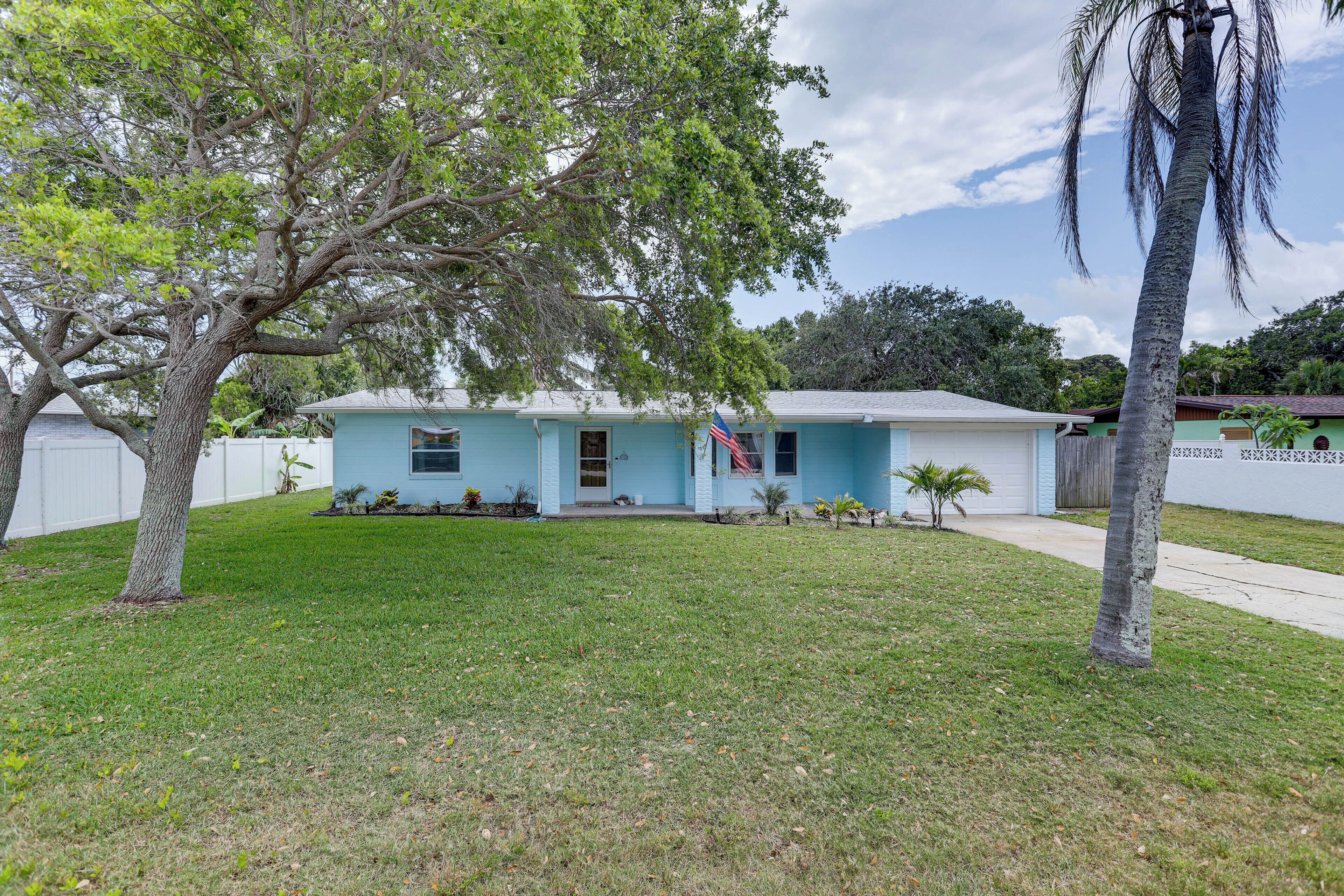 A single-story house with a front yard and a flag.