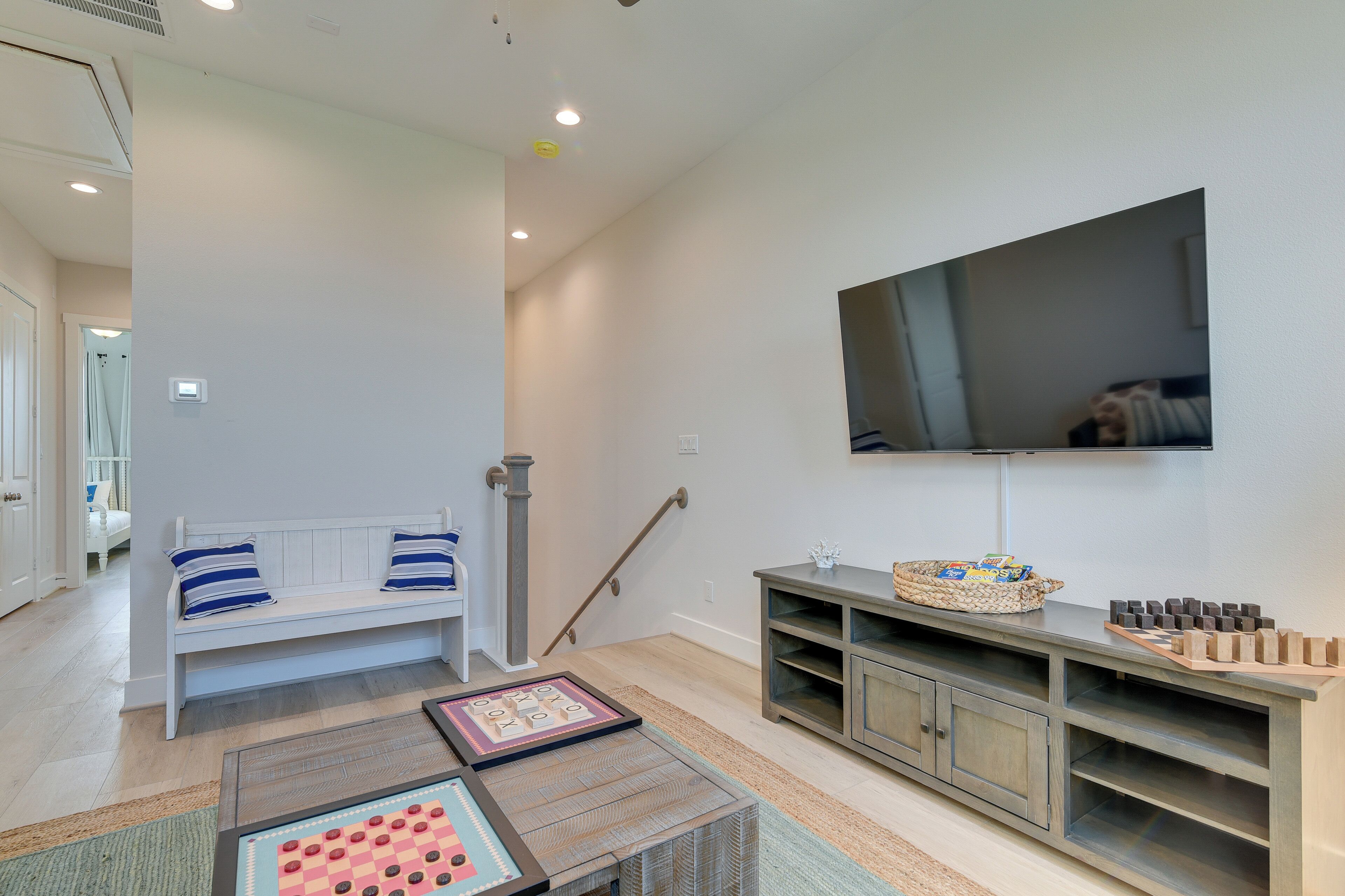 Un salon avec un banc, un téléviseur et un espace de jeux en bois.