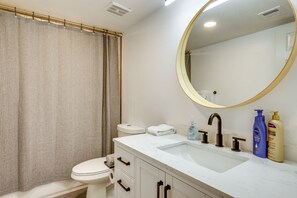 A bathroom with a toilet, sink, mirror, and toiletries. - Chandler Vacation Rental w/ Pool & Hot Tub Access (Chandler)
