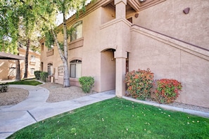 A residential building with a beige exterior, a well-maintained lawn, and a small garden with red-leafed shrubs. - Near Westworld & TPC Golf: Scottsdale Gem w/ Pool (Scottsdale)