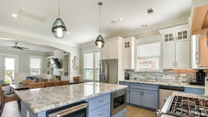 A modern kitchen with a large island, built-in appliances, and pendant lighting. - Walk to Ocean! Group Beach House in Galveston (Galveston)