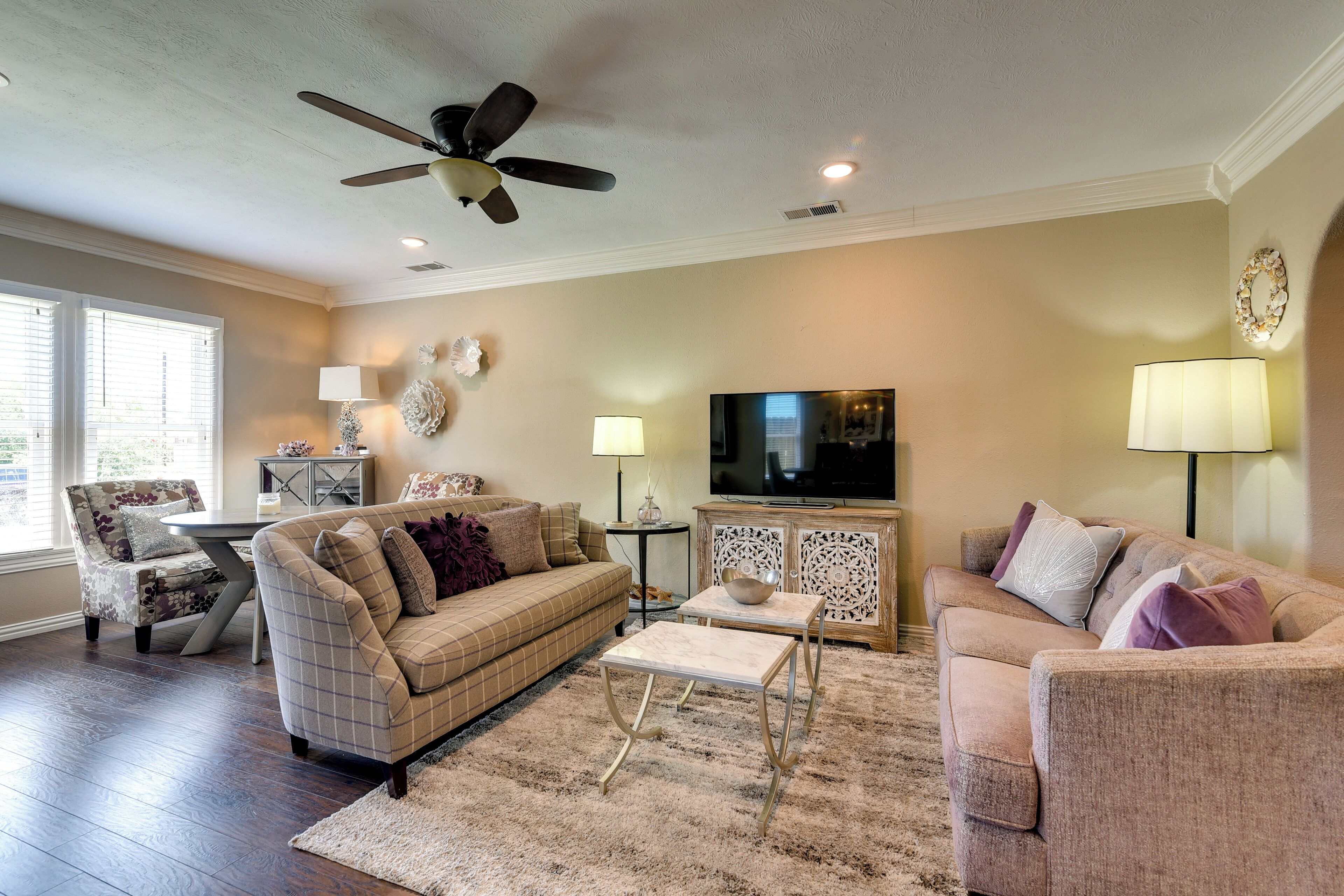 A living room with a ceiling fan, two couches, a television, and a coffee table.