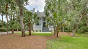 A house with a front porch, surrounded by trees and a lawn. - Family-friendly Hilton Head Island Getaway w/ Deck (Hilton Head Island)